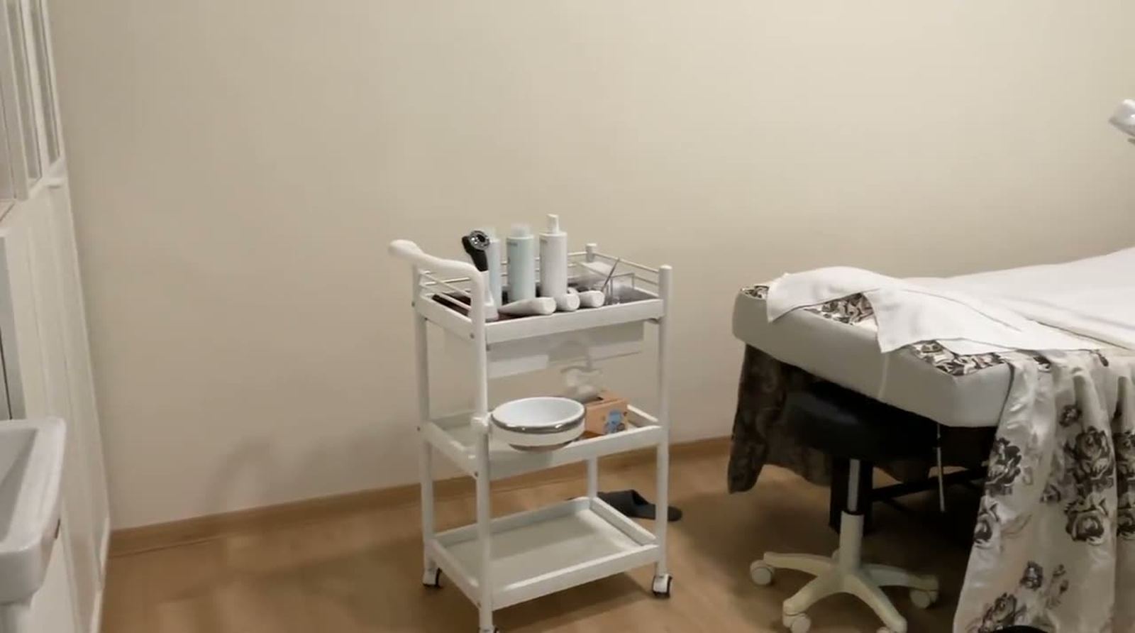 A facial trolley with cleansers and serums beside a made-up treatment bed at Vajra Sree Beauty.